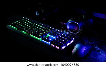 Gamer workspace concept with gaming gear, mouse, keyboard, joystick, Headset and mouse mat on table background with RGB Color.