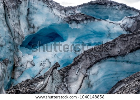 Textures and details of the crevasses and shapes left on the blue ice of an Alaskan glacier 