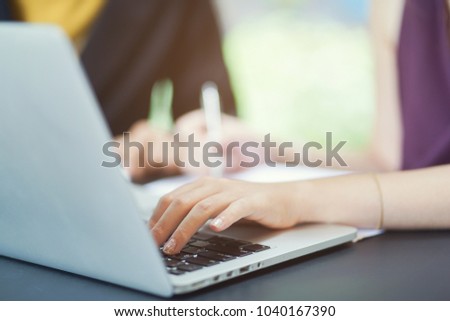 close up business woman hand finger typing keyboard laptop for explain detail statistic graph with partner or colleague concept 