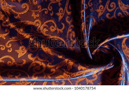 Texture, background, pattern. silk cloth Royal monogram. Moses Velvet with a design of gold foil lilies. Soft, light velvet depicts a playfully twirled design in decadent gold.