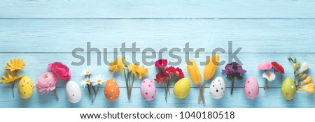Easter eggs and spring flowers on wood