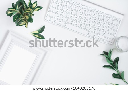 Woman's workplace with white frame, candle, spindle tree and keyboard. Top view