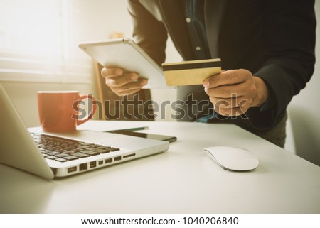 Hand  Business working using tablet, laptop online banking payment communication network at office interior blurred background of light bokeh.