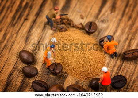 Miniature figures working on instant coffee macro photography on wood table