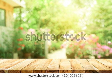 Empty wood table top on blur abstract green from garden and house background. For montage product display Royalty-Free Stock Photo #1040236234