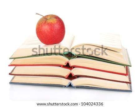 stack of open books with apple isolated on white