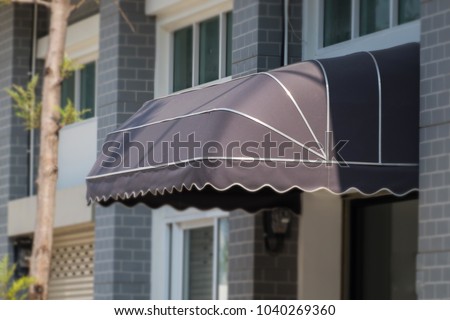 awning mounted on the front door of the shop. Royalty-Free Stock Photo #1040269360