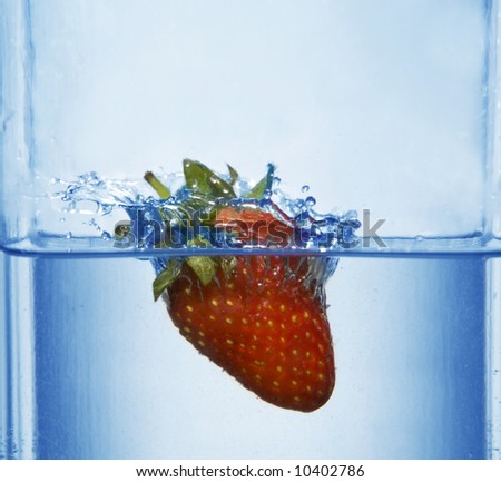 splashing strawberry into a water
