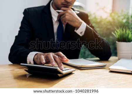 Businessman accouting management with calculator marketing report taking note balance of money statement on paperwork in office room
