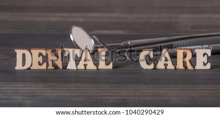 'Dental Care' words with dental tools on dark wooden background