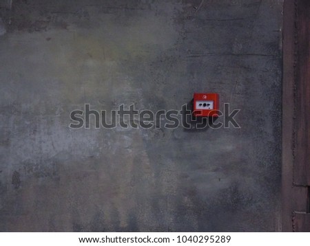 Grey wall and fire button. Dark abstract background with the wall.