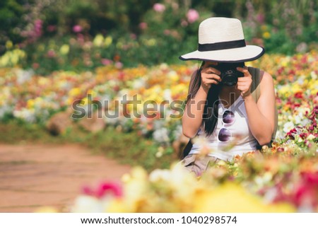 young beautiful girl tourist travel taking picture in flower garden weekend holiday lifestyle park outdoor nature background, photography journey backpack adventure outdoor with copy space.