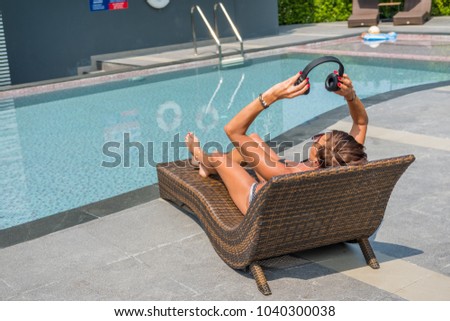 Beautiful woman enjoying summer  at the  pool