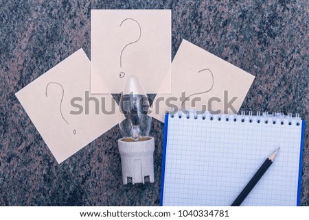 Bulb cartridge sheets of paper with a question mark, Notepad with pen closeup
