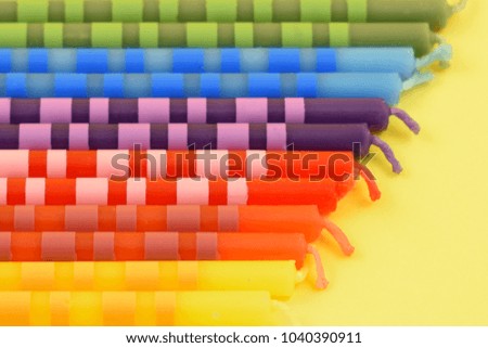 Colored birthday candles stock images. Multi colored cajke candles. Colored candles on a yellow background