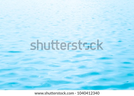 Abstract photo of sun light reflecting or sparkling glitter on water of sea or ocean with beautiful sky blue light tone.