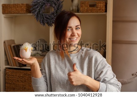 Woman holding Easter egg with chick. Happy Easter concept
