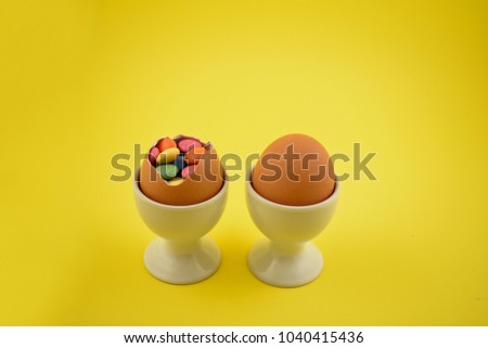 Candy easter eggs stock images. Easter eggs on a yellow background. Spring decoration images. Easter decoration. Sweet egg with surprise. Egg filled with candy. Easter concept