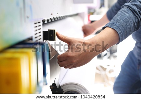 Work in the printing house.
The printer works on a plotter.
 Royalty-Free Stock Photo #1040420854