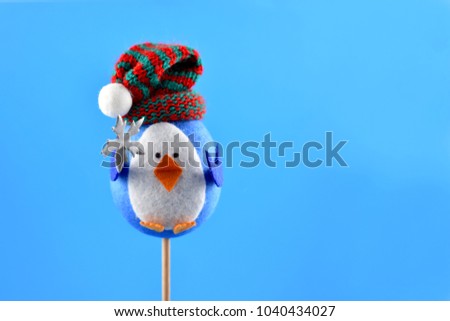 Toy bird stock images. Bird figurine on a blue background. Decorative bird figurine. Cheerful bird with cap