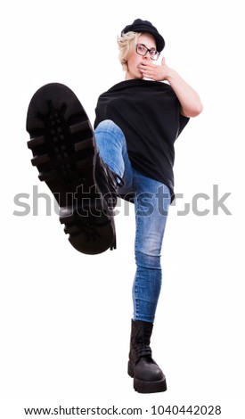 Young fashion stylish woman in big black boots with the step on the photo camera. Isolated portrait on white background in full body in the front wide angle view. Grunge style. Vipster