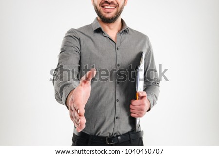 Cropped picture of cheerful businessman standing isolated over white background looking camera give you a hand for handshake.