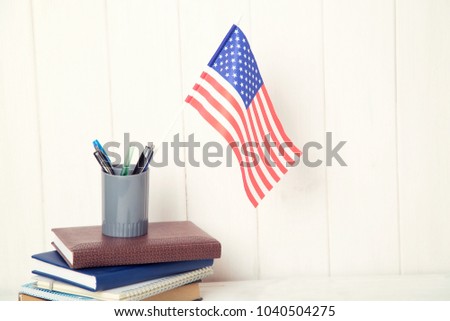 Books and the US flag on the desk. English language learning. Flag the United States of America.
