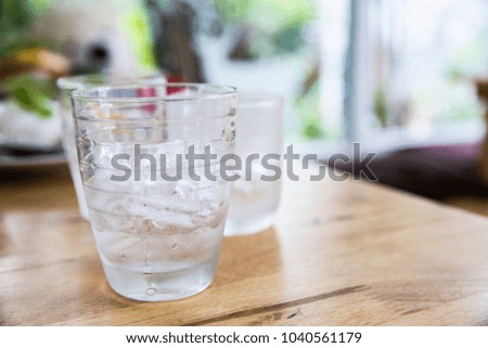 Glass of water with ice on wooden table