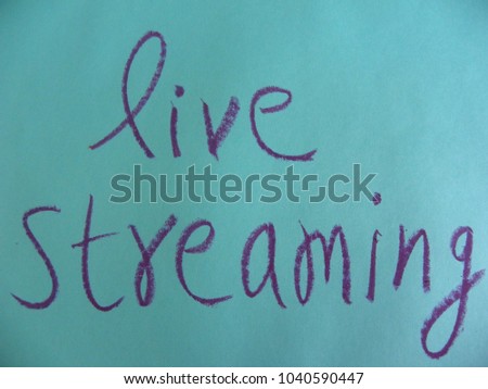 Text live streaming hand written by purple oil pastel on blue color paper