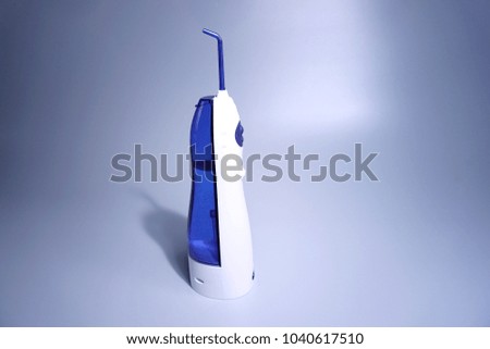 Space for your text. Oral hygiene. Irrigator for cleaning teeth on gray background.