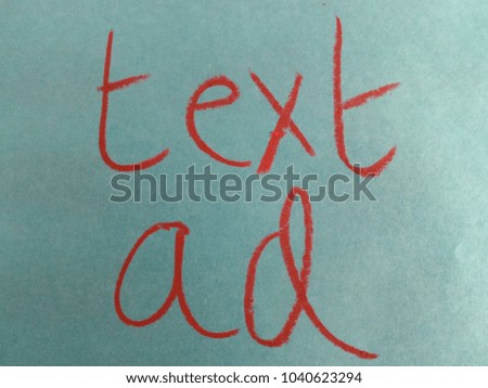 Text text ad hand written by red oil pastel on teal color paper