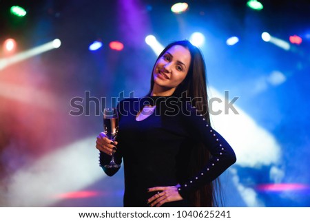 Closeup of happy mixed race woman in sequined dress dancing on a party over colorful background.