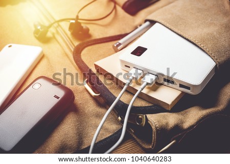 smartphone charging with white power bank. close-up at white power bank.  Royalty-Free Stock Photo #1040640283