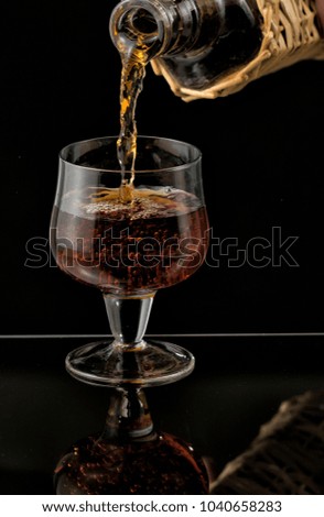 Cognac is poured from a bottle into glass