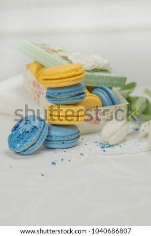 Yellow and blue pasta in a semi-closed blue gift box, decorated with lace ribbon and flowers. Sweet pasta in a gift box.