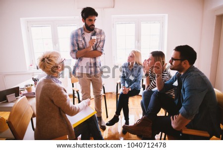 Young people with problems listening to their nervous friend confession while sitting together on special group therapy. Royalty-Free Stock Photo #1040712478