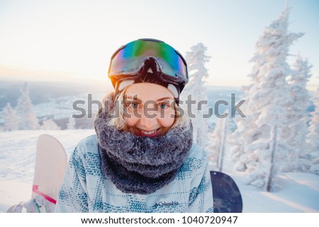 Girl is making a selfie in ski mask, in background there is snow. His hair was icy with frost, initsi action camera.