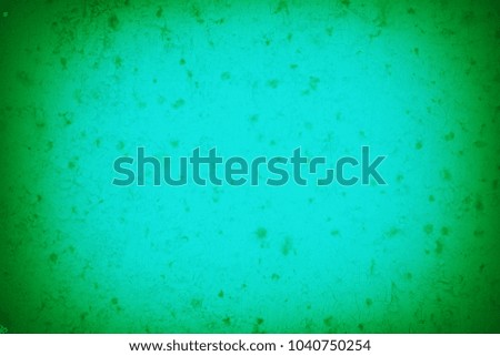 The flat surface of the wall is painted in bright green color. Texture of a concrete wall with vignetting.