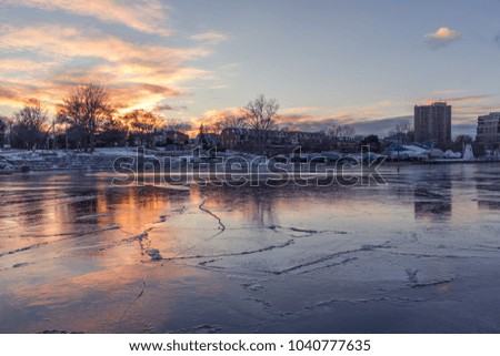 Iced river lake with beautiful sunset and a fantastic sky.