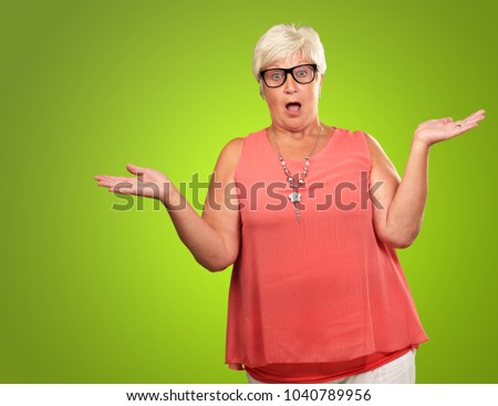 Portrait Of A Surprise Mature Woman On A Green Background