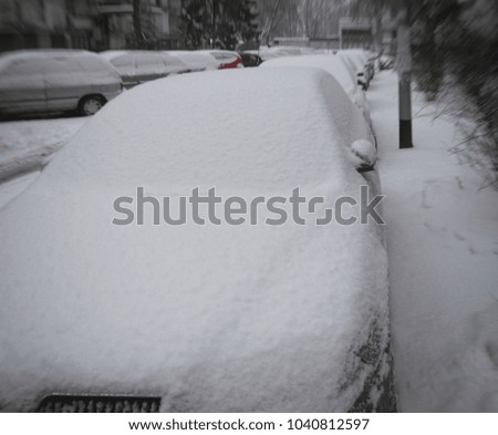 Cars under the snow in the city, blurred image