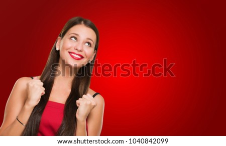 Portrait Of Young Woman Looking Up and Gesturing against a red background