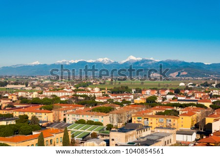 High view on the city of Pisa with snow peaks of mountains on the background