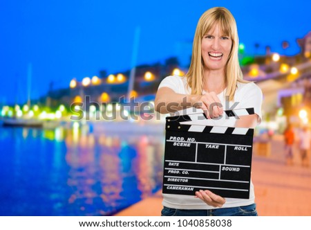 Happy Woman Holding Clapper Board at a port