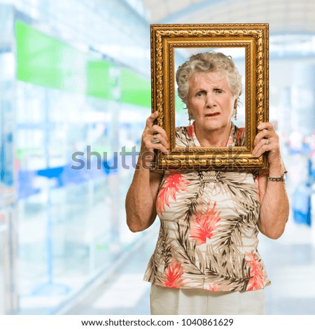 Senior Woman Holding Picture Frame, Indoors
