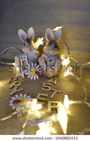 Two Rabbits, flowers, lighting Toadstools and Inscription Happy Easter from wood Letters