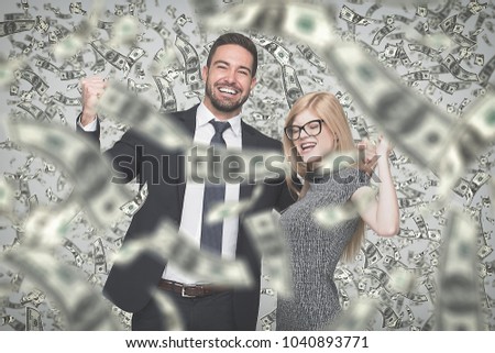 Happy young caucasian businessman and businesswoman in money rain, winning contract or lottery
