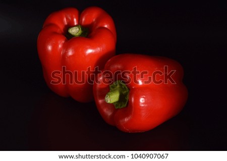 Bright red peppers on a seamless black background