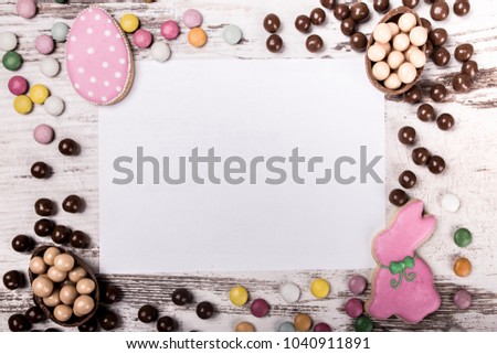 Easter gingerbread cookies and  greeting card  on wooden table.Eggs and chocolate balls. View from above.Copy space.
