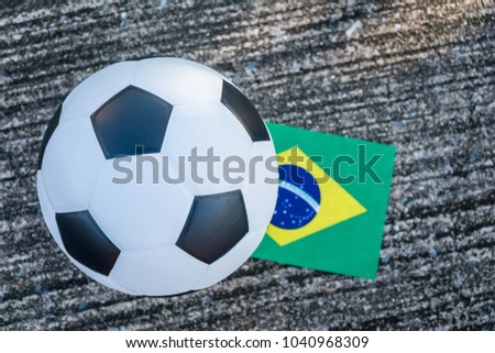 Above view of leather soccer ball with Brazil national flag of the participating countries in the tournament on the street. Football equipment to play competitive game.World cup, Top-down Royalty-Free Stock Photo #1040968309